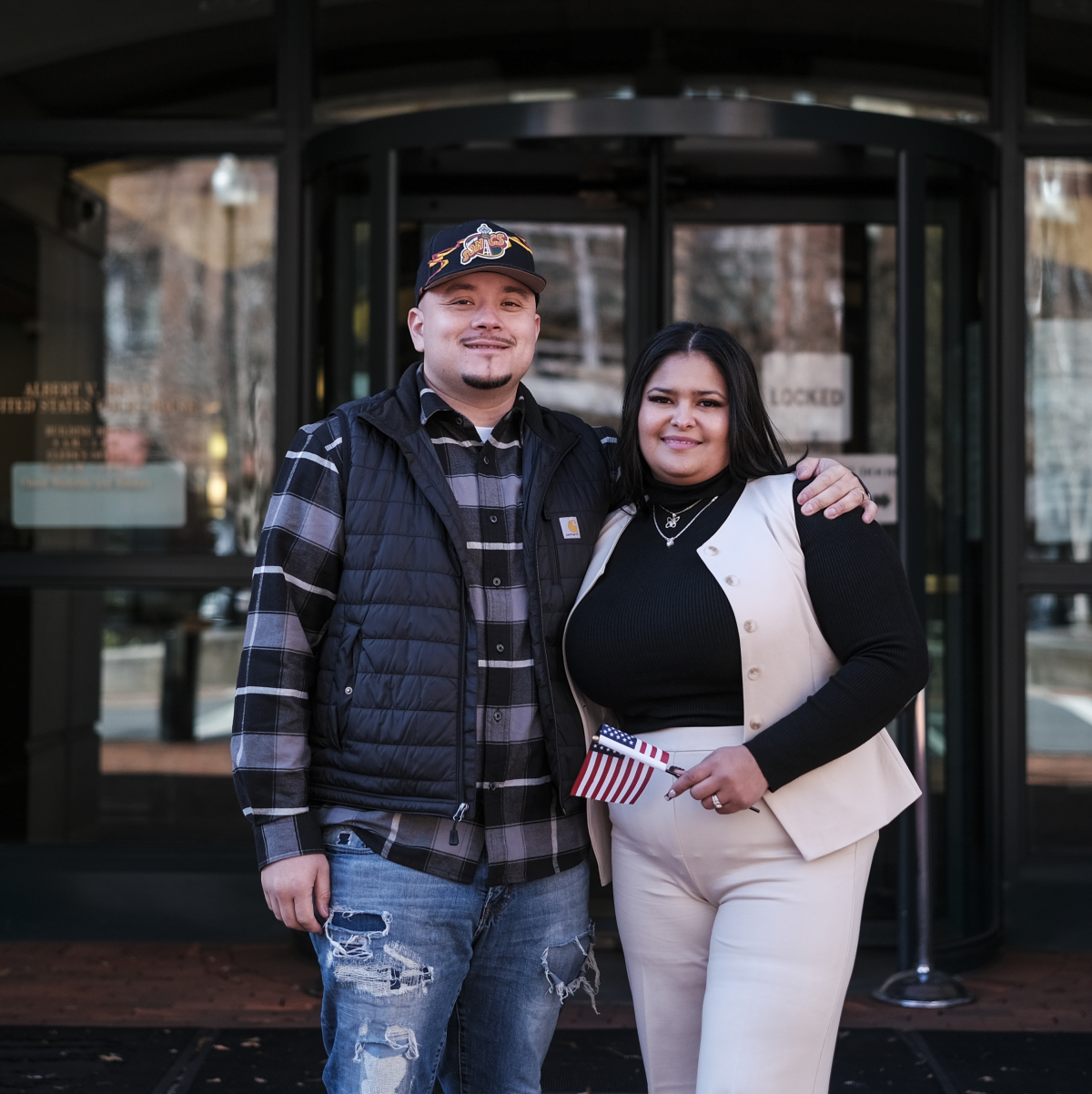 Ashley Lezama (right), of Honduras, stands with her husband, Nick Moreno, of Bolivia following her naturalization ceremony in Alexandria, Va.