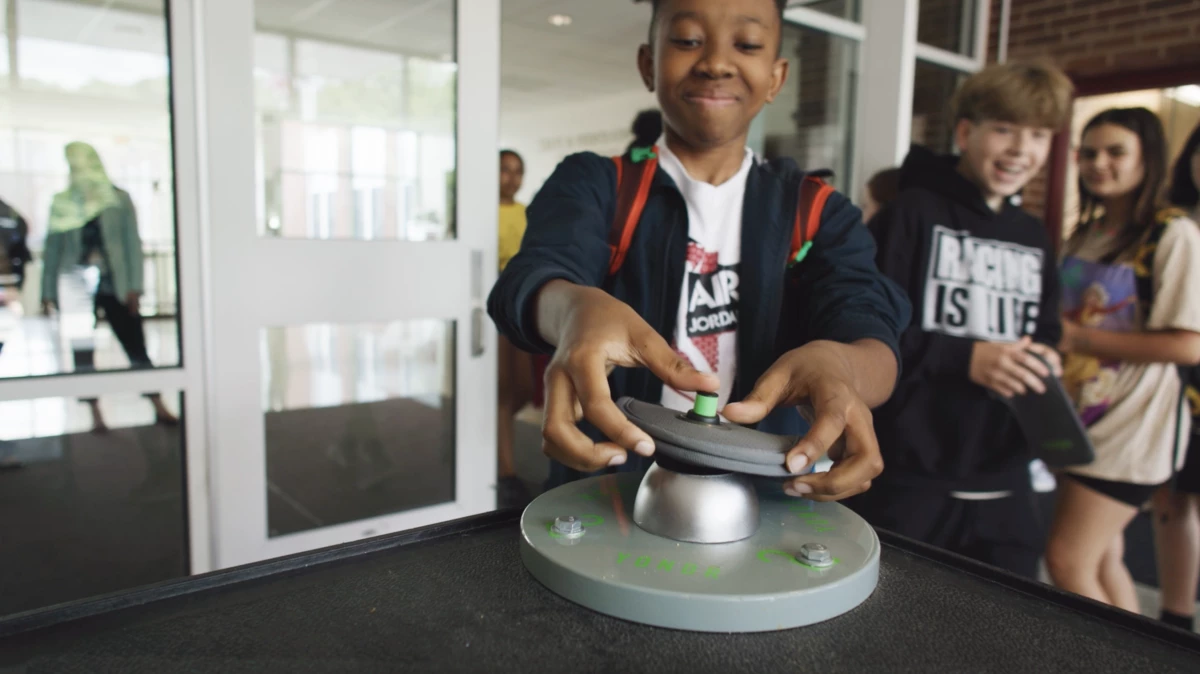 Students use a special magnet to unlock pouches at an 'unlocking base' at school.