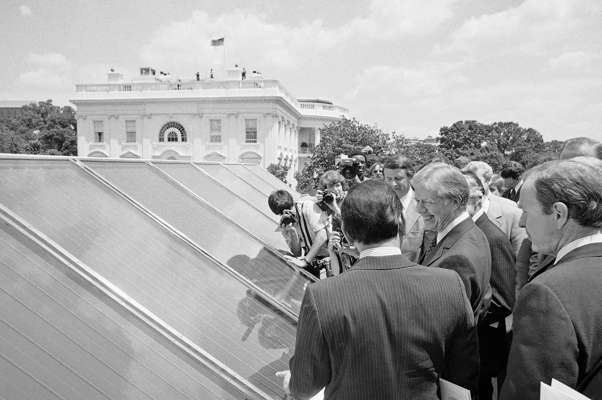 President Jimmy Carter, center, inspects the new White House solar hot water heating system located on the roof of the West Wing in June 1976.
