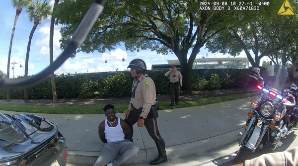 This screen capture from bodycam footage of Miami-Dade Police shows an officer detaining Miami Dolphins player Tyreek Hill following a traffic stop on Sunday.