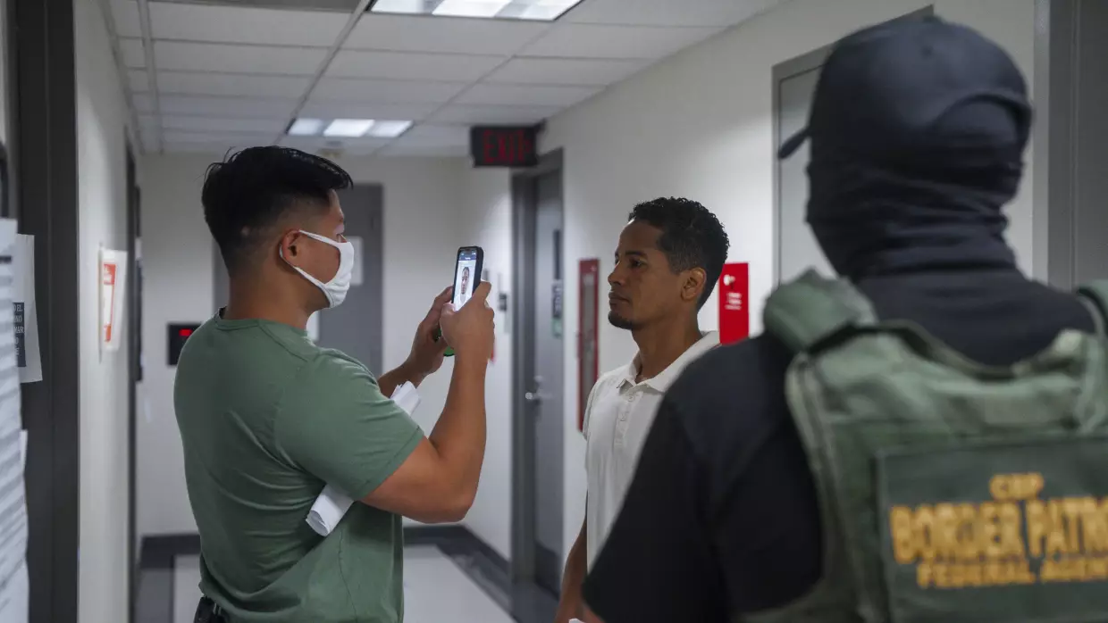 A federal immigration agent uses facial recognition software to confirm an asylum seeker's identity prior to an immigration hearing on July 30, 2025, in New York. In addition, DHS is expanding its use of iris scanners to help quickly identify undocumented immigrants.