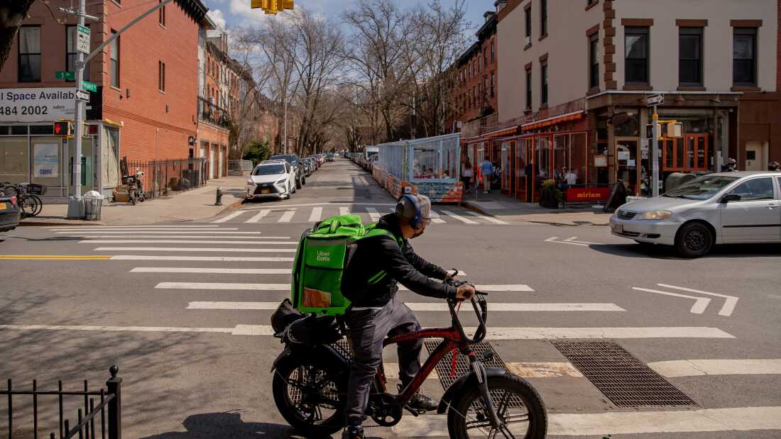 An Uber Eats delivery person rides an electric bike through the Park Slope neighborhood of Brooklyn, New York.