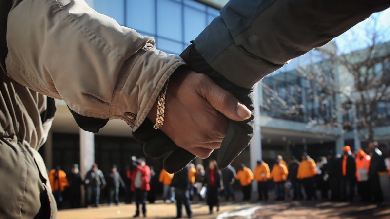 Students and community leaders pray outside a Chicago High School in the aftermath of a student's death from gun violence.