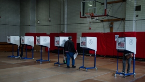 A voter carries a ballot during early voting for New York City's mayoral election on Oct. 25, 2025.