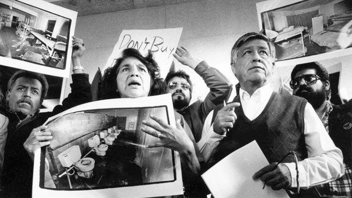 United Farm Workers leaders Dolores Huerta and Cesar Chavez display photos of the conditions that farmworkers endure in San Joaquin Valley farm labor camps at a news conference outside U.S. District Court in Fresno, California, on Nov. 21, 1989.