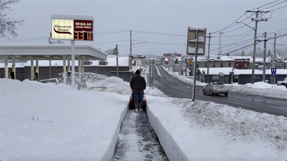 A person clears the snow from the sidewalk in Lowville, N.Y., on Saturday, Nov. 30, 2024. 