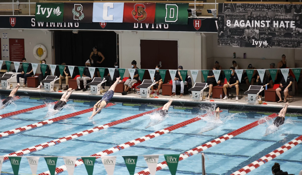 Swimmers including Penn's Lia Thomas, lane 4, dive into the water at the start of a qualifying heat of the 200 yard freestyle at the Ivy League Women's Swimming and Diving Championships at Harvard University, Feb. 18, 2022, in Cambridge, Mass.