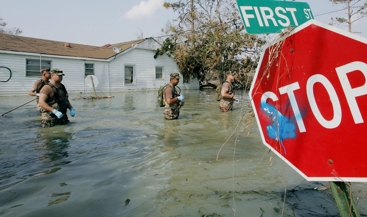 Members of the New Mexico National guard wade through water to check for bodies in homes destroyed after Hurricane Katrina passed through Sept. 10, 2005 in Port Sulphur, La.
