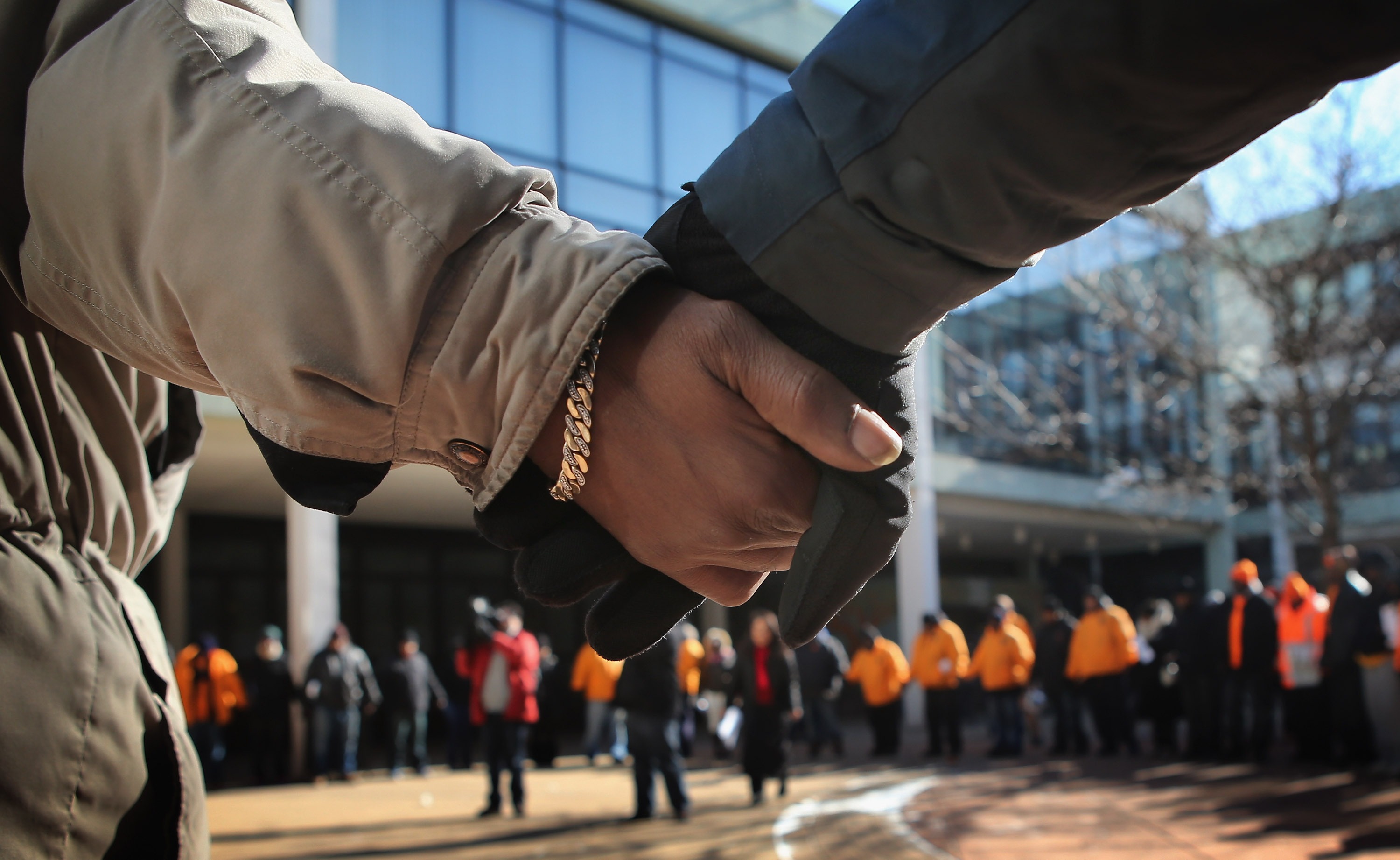 Students and community leaders pray outside a Chicago High School in the aftermath of a student