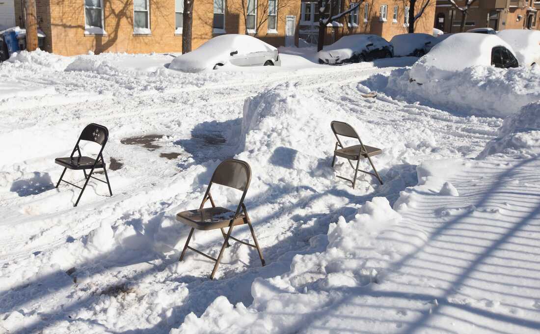 Residents use folding chairs to reserve a parking spot on the street after digging a car out from the snow on Feb. 2, 2015, in Chicago. Snow began falling in the city Sunday morning and did not stop until early Monday morning, leaving behind 18 inches. It was the fifth largest snowfall in the city's history. (Photo by Scott Olson/Getty Images)