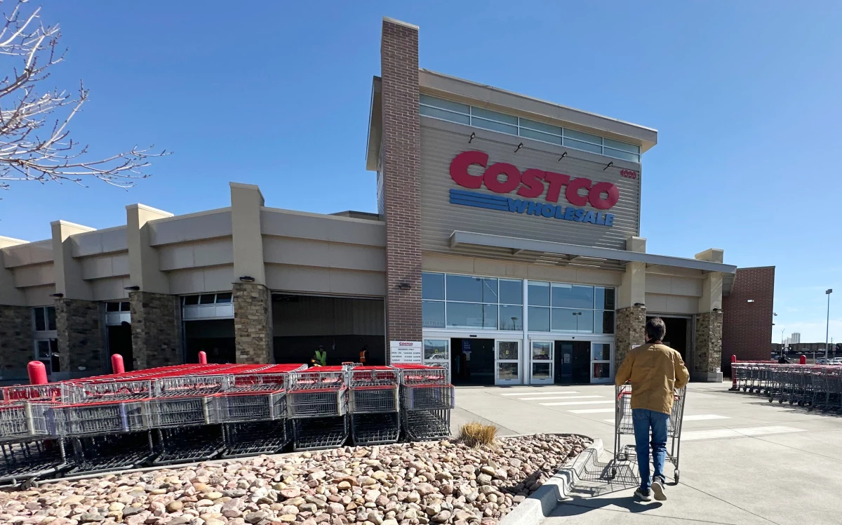 A shopper pushes a cart toward the entrance of a Costco warehouse in Colorado.