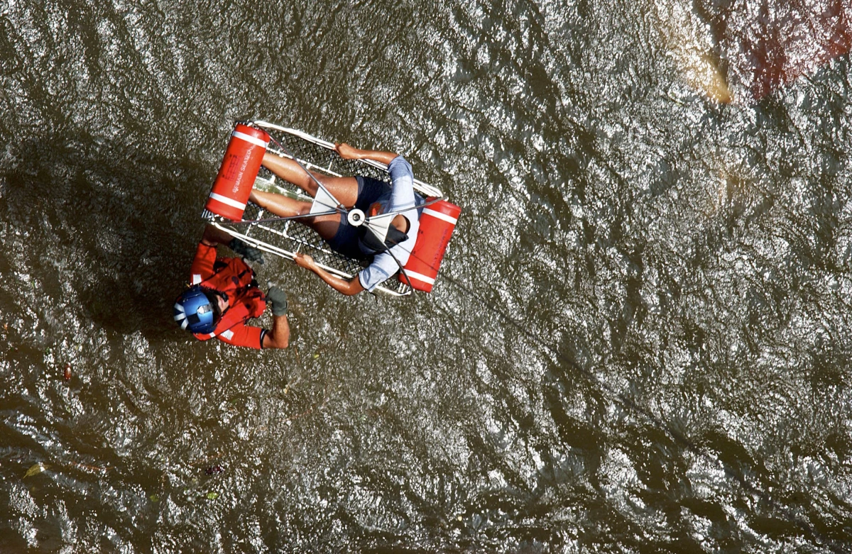 In this U.S. Coast Guard handout, U.S. Coast Guard Petty Officer Scott D. Rady of Tampa, Fla., gives the signal to hoist a pregnant woman from her apartment in the aftermath of Hurricane Katrina on Aug. 30, 2005 in New Orleans. According to the Coast Guard, they rescued 11 survivors from the apartment building.
