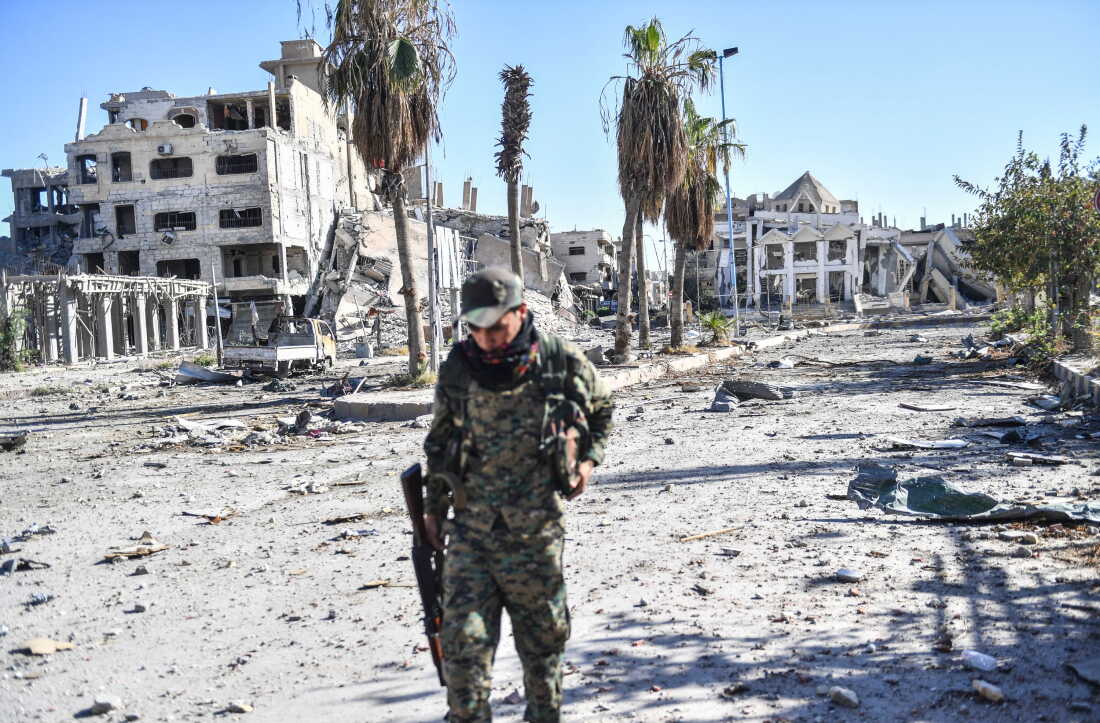 A member of the Syrian Democratic Forces (SDF) walks through a heavily damaged a street leading to an Armenian church in Raqa on October 18, 2017. The SDF fighters flushed jihadist holdouts from Raqa's main hospital and municipal stadium, wrapping up a more than four-month offensive against what used to be the inner sanctum of IS's self-proclaimed "caliphate".