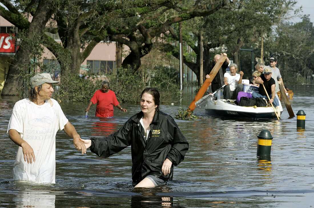 People on Canal street make their way to higher ground as water fills the streets August 30, 2005 in New Orleans, Louisiana.