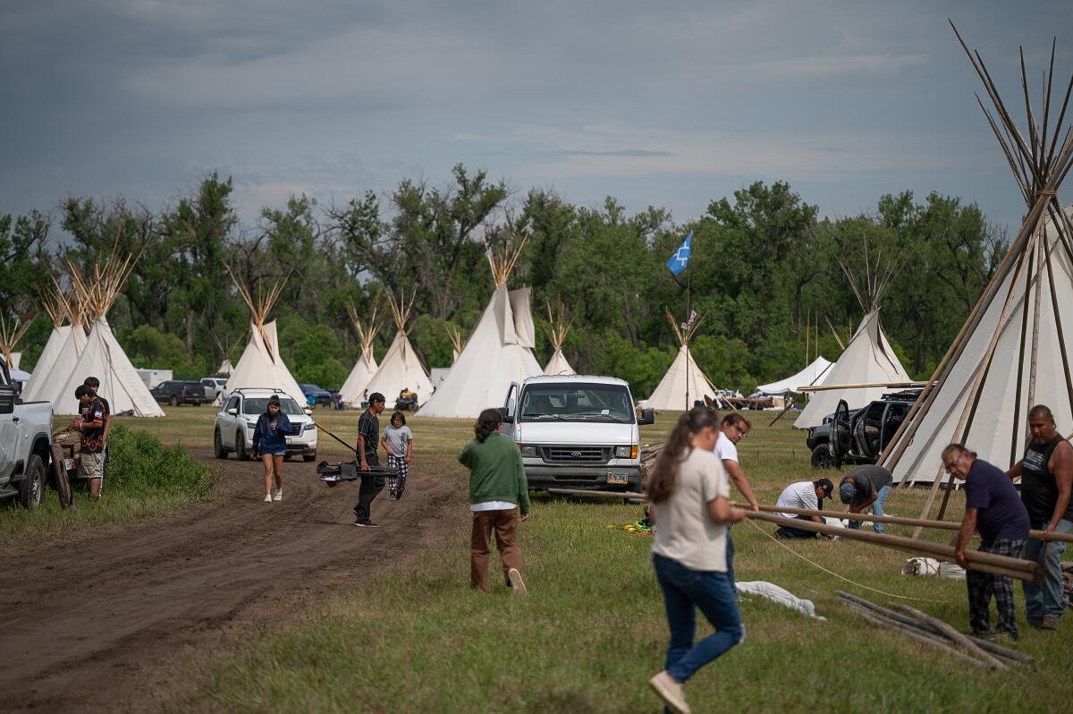 People are taking down tipis at an encampment along the Little Bighorn River during the 150th anniversary commemoration of the Battle of the Little Bighorn near Little Bighorn Battlefield National Monument. The encampment brought together tribal members from across the Plains for ceremonies, storytelling and remembrance.