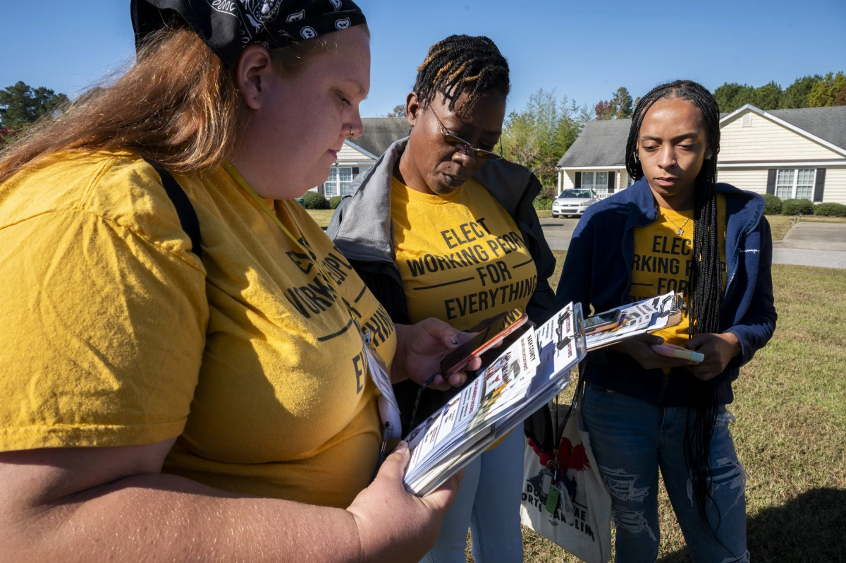 (From left) canvassers Arquette Turnage, Andrea Farmer and Tynia Anstead check their list of potential voters.