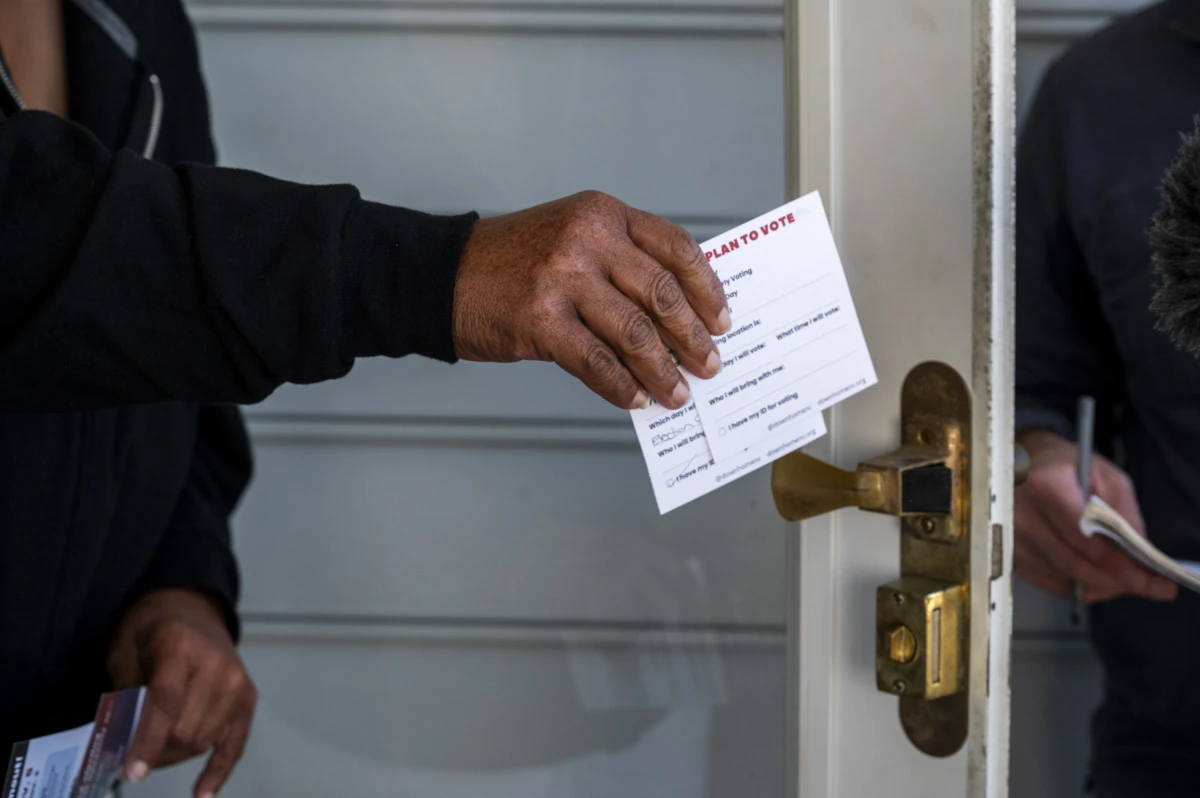 Down Home North Carolina canvassers pass out cards with voting information.