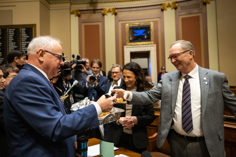 Rep. Paul Torkleson, R-Hanska, accepts an apple blondie from Gov. Tim Walz before the Minnesota House begins their session at the State Capitol on Monday, Feb. 12, 2024. (MPR News)