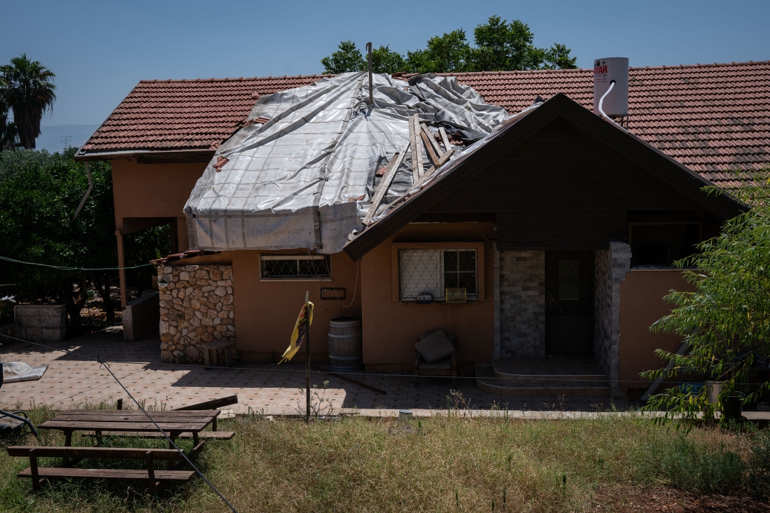 A tarp covers a hole in a hoes roof from rocket damage from Hizbollah seen in the Israeli town of Kiryat Shmona on the Lebanon border on June 10.