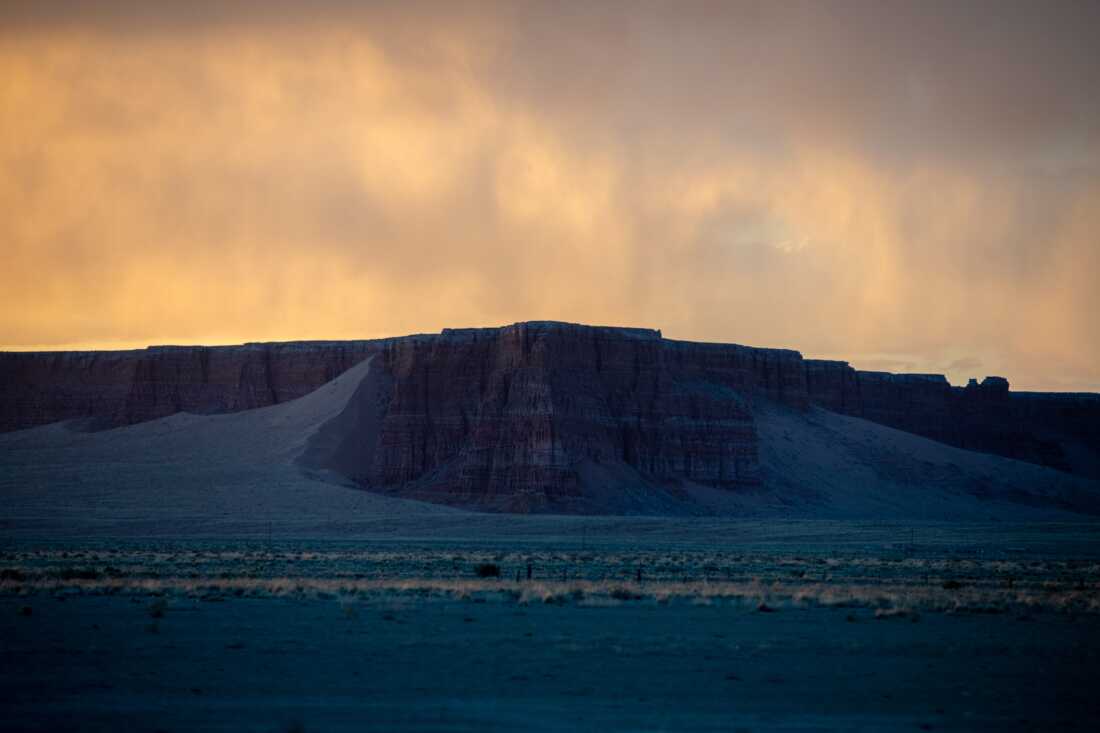 The sun sets over a quiet highway leading to the three mesas of the Hopi Reservation in Arizona.