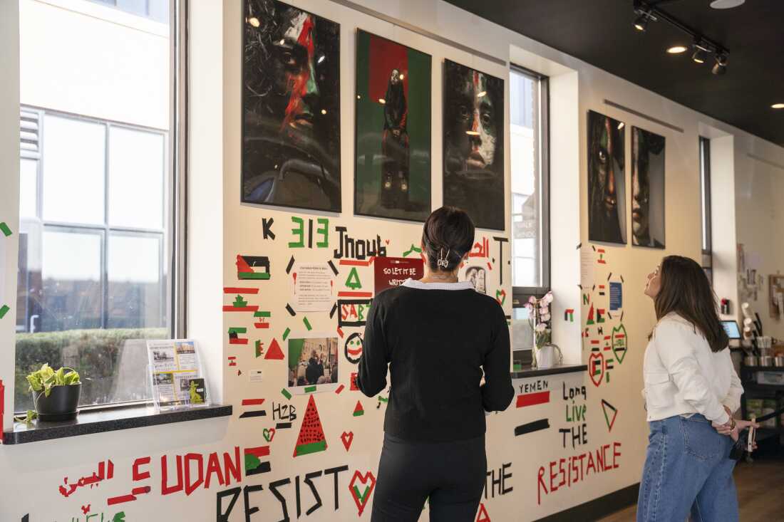 Lisa Alcodray speaks with a customer about the exhibition inside the Black Box Cafe on Thursday, Oct. 10, 2024, in Dearborn, Michigan.