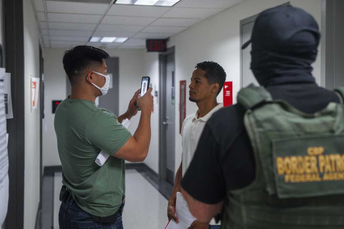 An Immigration and Customs Enforcement (ICE) agent uses facial recognition software to confirm an asylum seeker's identity prior to an immigration hearing on July 30, 2025, in New York. In addition, DHS is expanding its use of iris scanners to help quickly identify undocumented immigrants.