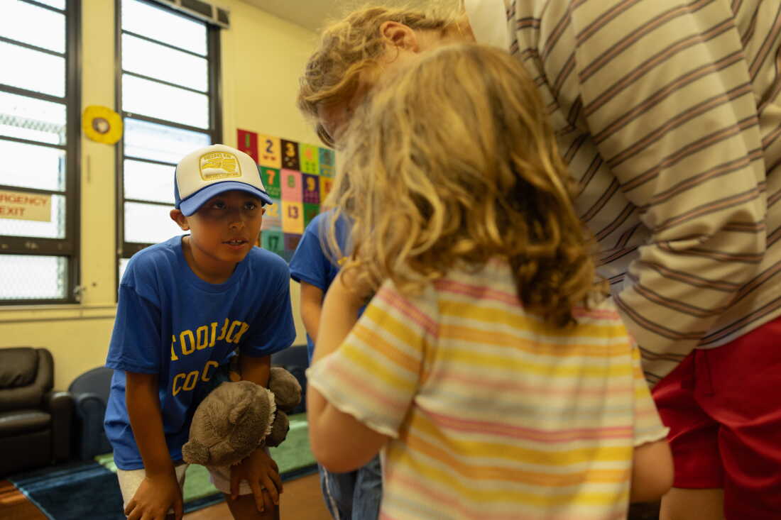 Fifth grader Gerald Gomez-Reina welcomes a new kindergartener into a classroom at Micheltorena Elementary School in Los Angeles, keeping his own stuffed animal, Rocket the Raccoon, handy to comfort any nerves.