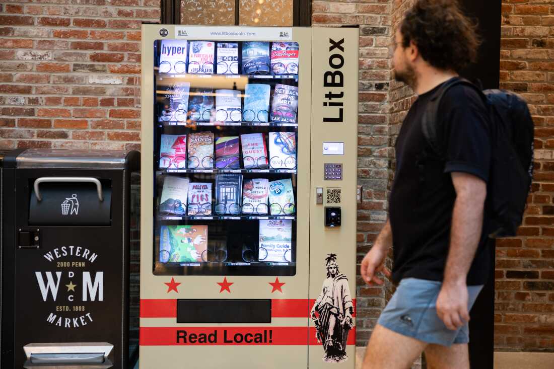Seorang pria berjalan melewati mesin penjual otomatis Litbox di ruang makan di Washington, DC