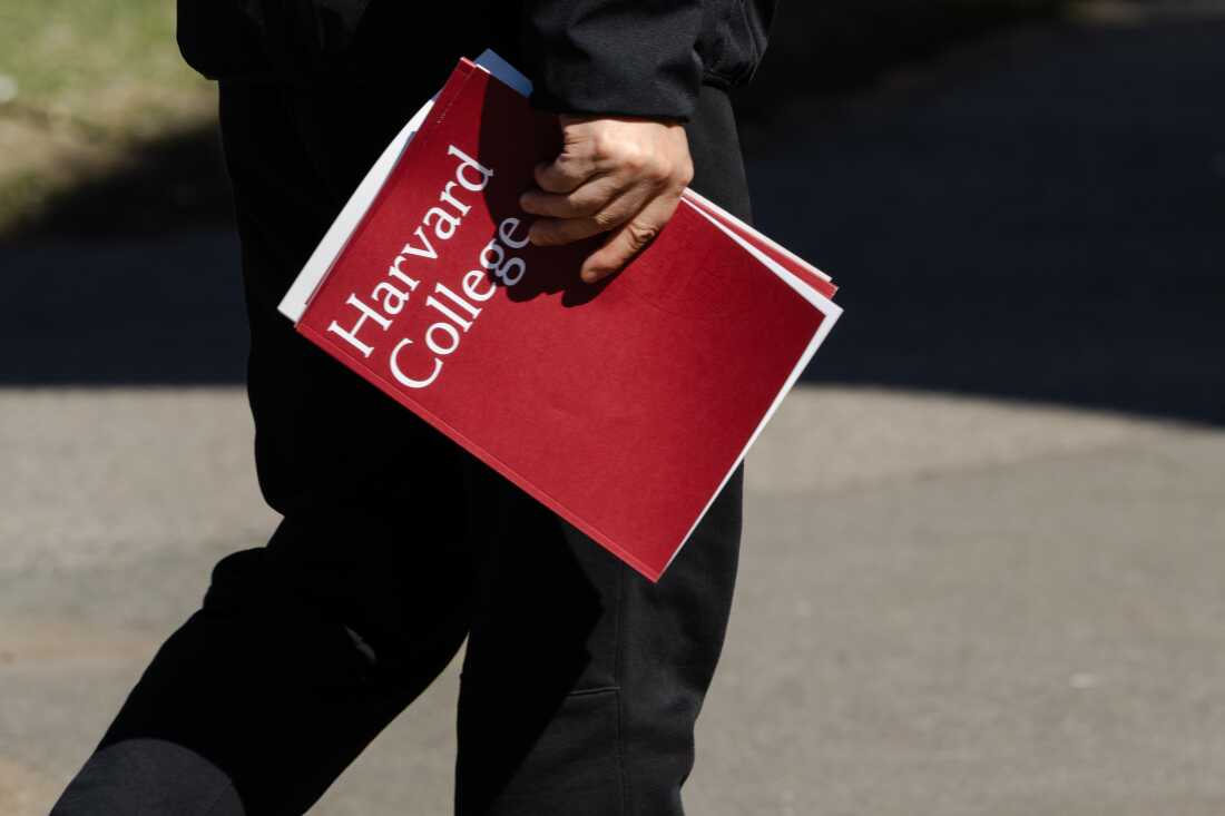 A person holds a Harvard College folder during a tour at Harvard University on April 17 in Cambridge, Mass.