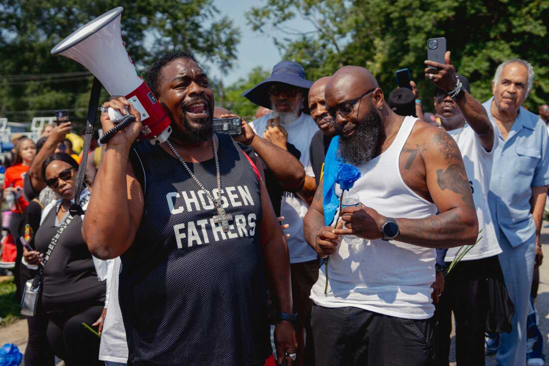 Andrew Joseph, 50, of Tampa Fla., reflects on Michael Brown Jr.’s death alongside his father Michael Brown Sr., right, on Friday, Aug. 9, 2024, at the end of a unity march commemorating a decade after Brown Jr.’s police killing in Ferguson.