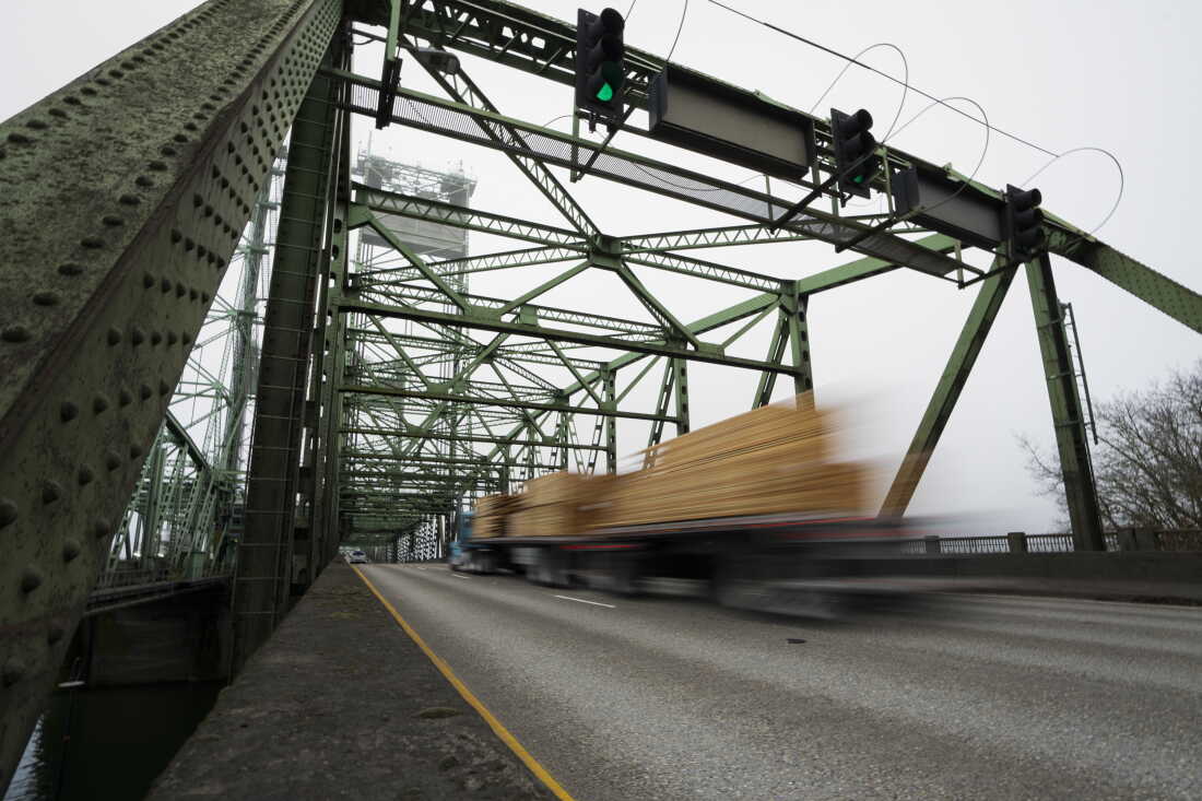 In this file photo, a logging truck drives on the Interstate 5 bridge that spans the Columbia River and connects Portland, Ore., with southwest Washington state, part of the 3rd Congressional District, on Feb. 13, 2024.