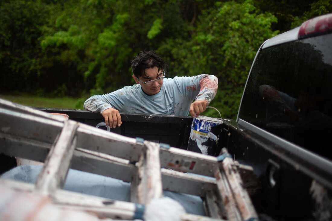 Yonatan Vasquez puts roofing supplies into his truck.