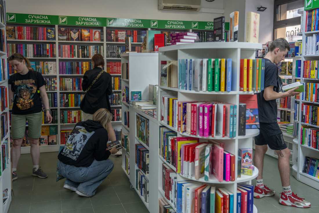 People peruse the bookshelves at the bookstore of Vivat, one of Ukraine's largest publishing houses, on May 26. A printing house used by Vivat was hit by a Russian strike a few days prior, killing seven workers.