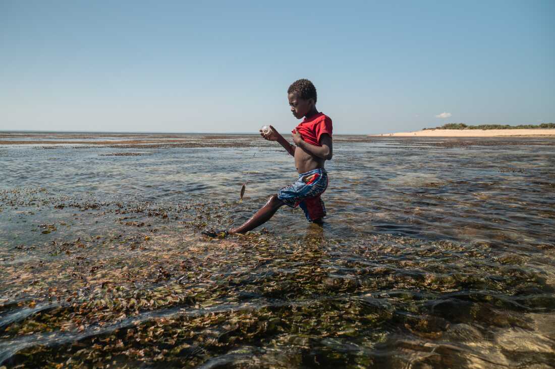 A child fishes with a string in the shallow waters of Nosy Maraontaly island, in Madagascar's Barren Isles.