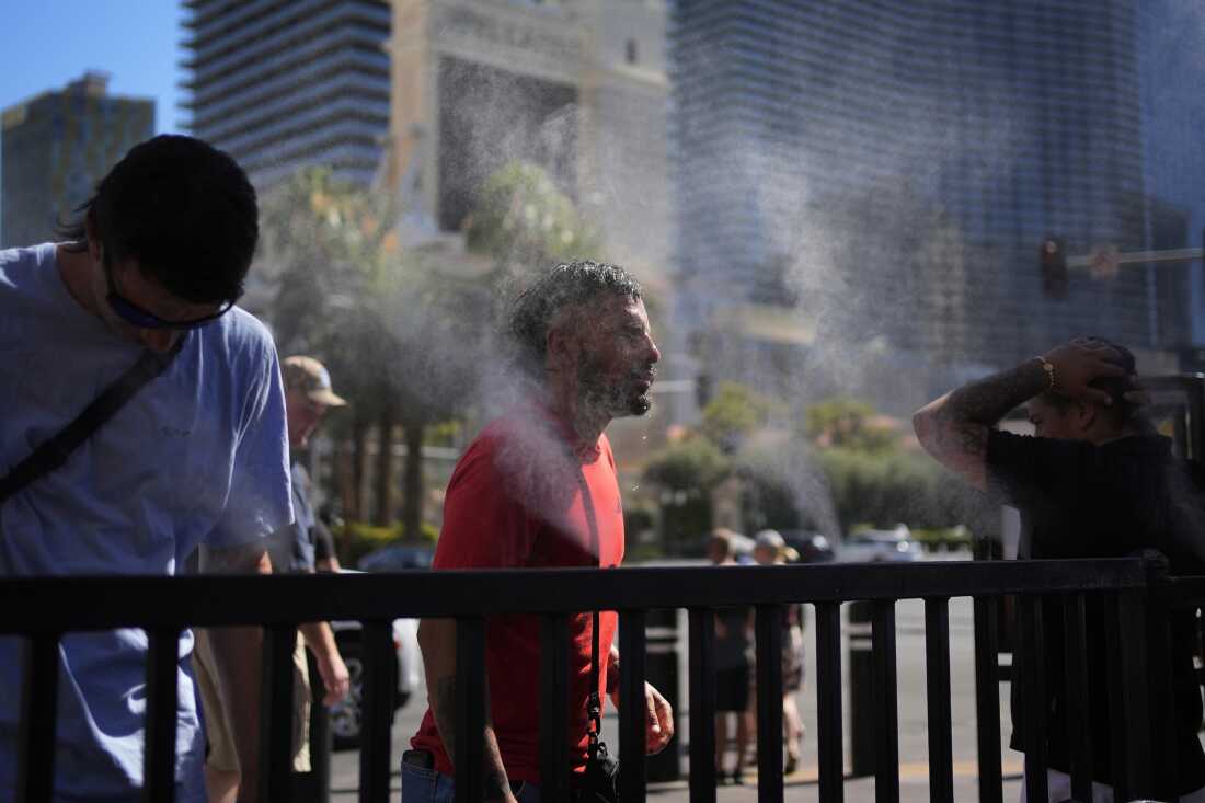 People cool off in misters along the Las Vegas Strip, Sunday, July 7, 2024, in Las Vegas. Used to shrugging off the heat, Las Vegas residents are now eyeing the thermometer as the desert city is on track Wednesday to set a record for the most consecutive days over 115 degrees (46.1 C) amid a lingering hot spell that's expected to continue scorching much of the U.S. into the weekend.