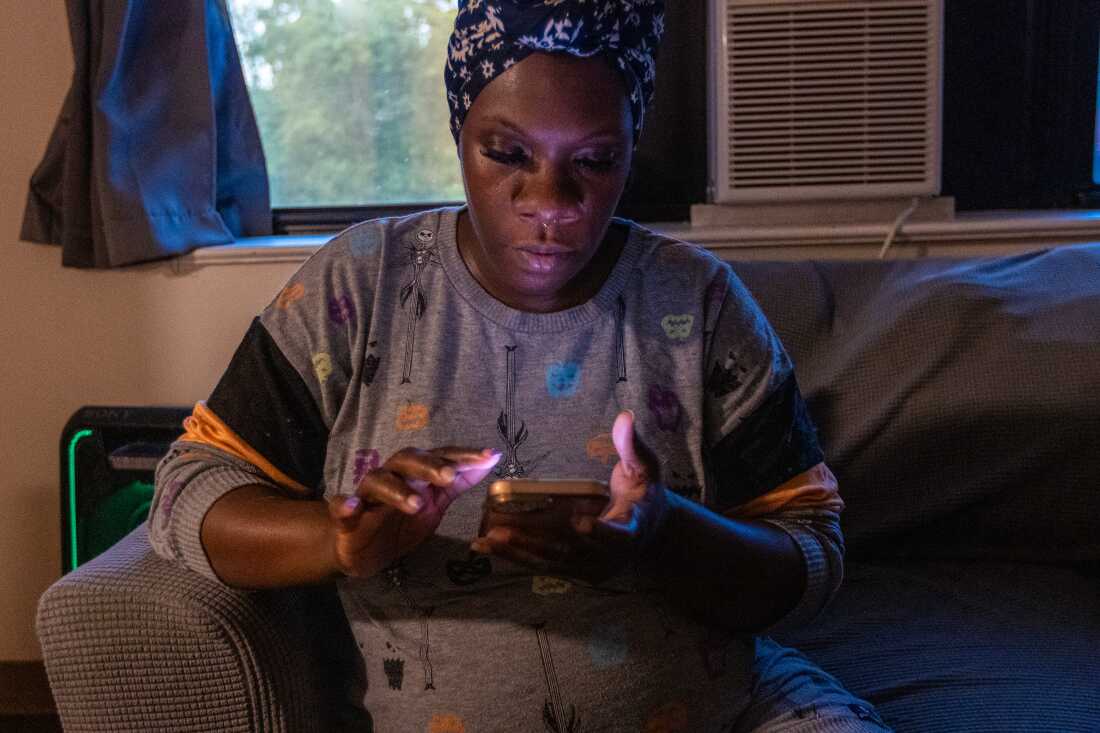 Kiki Polk checks her electric bill on her phone to see if the credit from the Clean Power Prescription has been applied to her account.