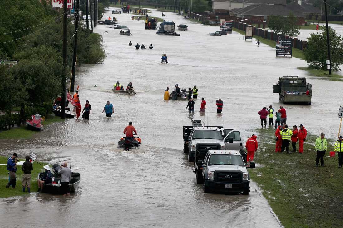 People make their way out of a flooded neighborhood in Houston after it was inundated with rain during 2017's Hurricane Harvey.