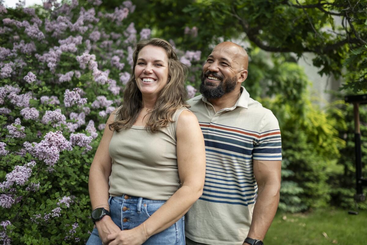 Alicia and Dave Carlson pose for a portrait in their home in Eau Claire, Wis., where they are raising three children.