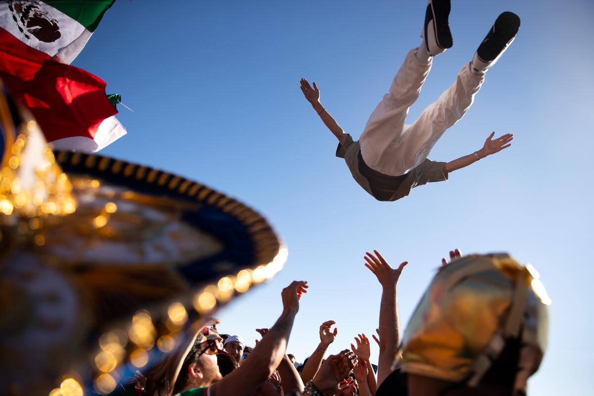 Soccer fans rooting for Mexico are launched into the air in celebration ahead of the FIFA World Cup knockout round match against England on Sunday, July 5, along the waterfront in Seattle.