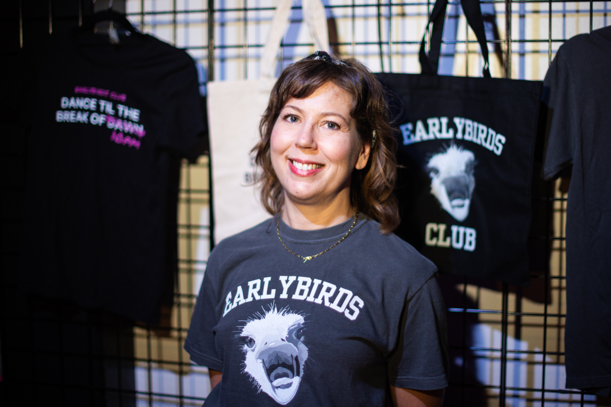Laura Baginski, co-founder of Earlybirds Club, stands next to merchandise at the start of the event.