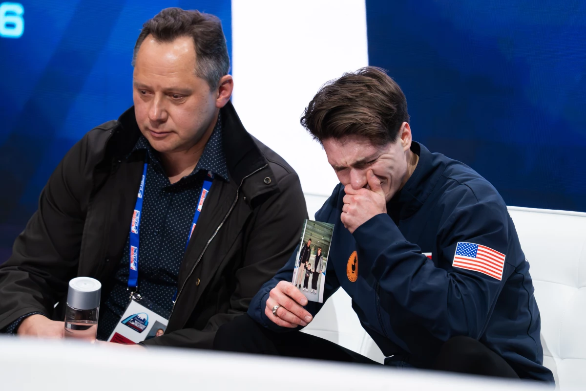 Maxim Naumov holds a photo of his parents while he waits for his scores after competing in the men's short program competition during the 2026 U.S. Figure Skating Championships in St. Louis on Jan. 8.