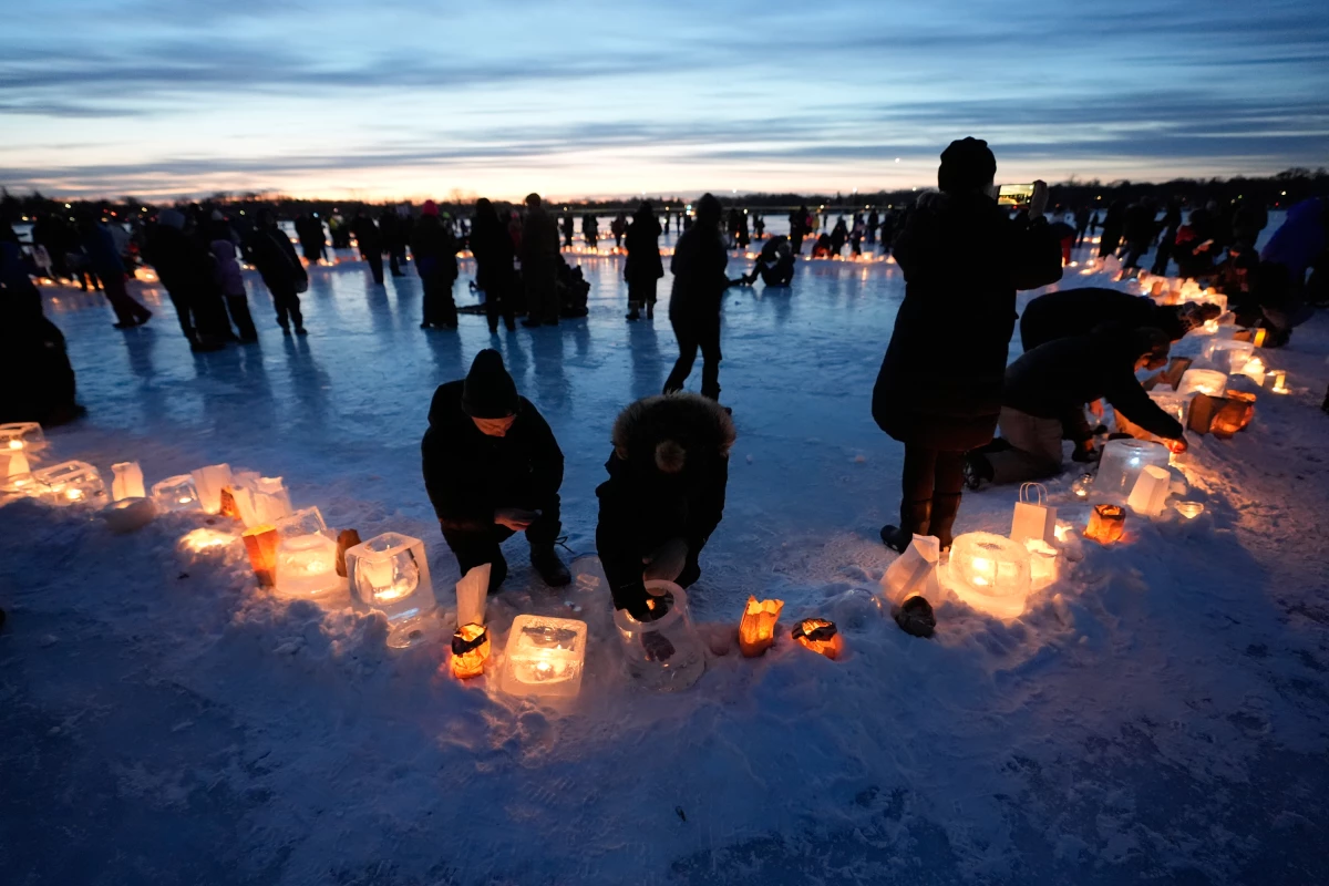 Activists gather in protest to light candles on frozen Lake Nokomis in Minneapolis, spelling, 'Ice Out' on Jan. 31, 2026.
