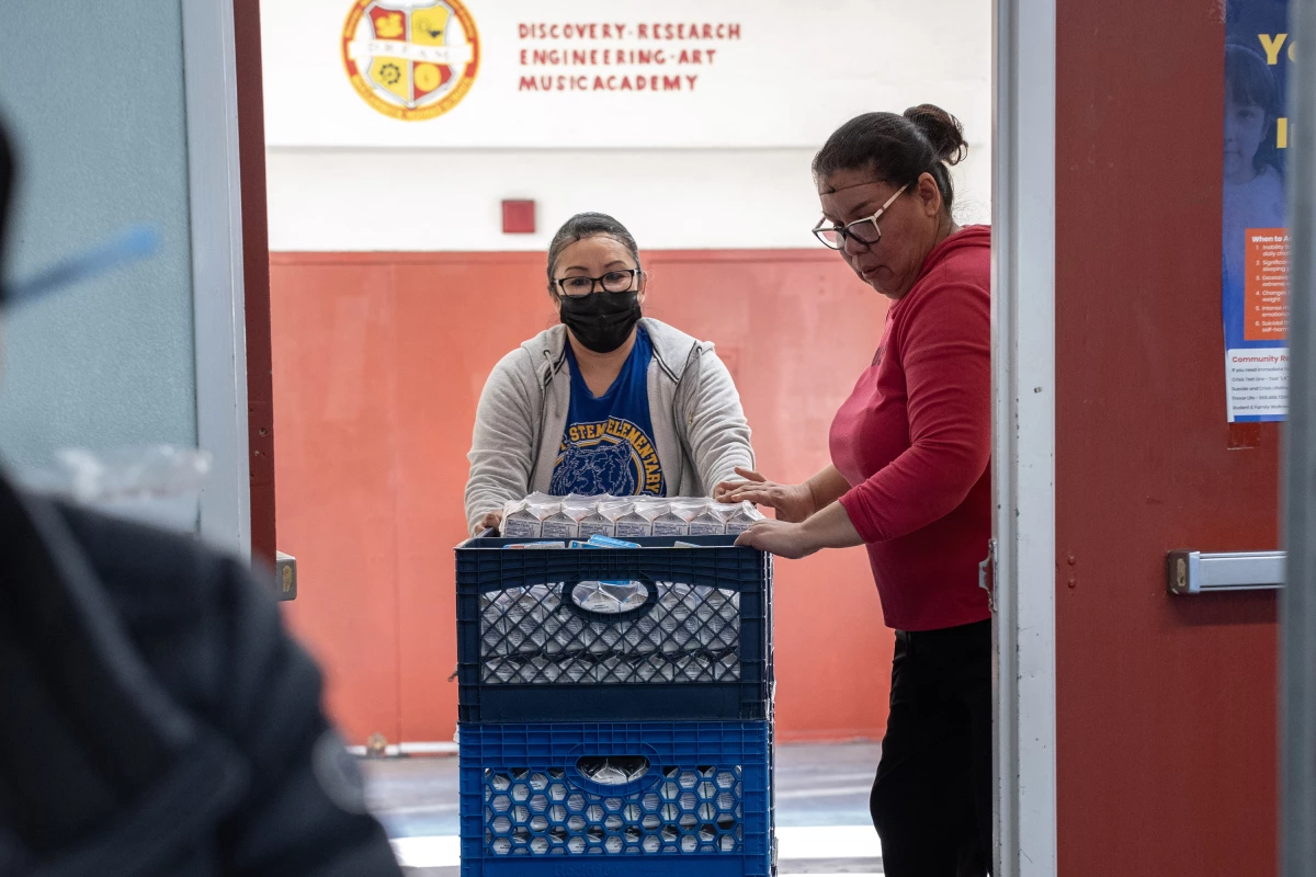Crates of milk cartons are rolled through the halls of Hollenbeck Middle School. LAUSD is providing two meals per student, per day.