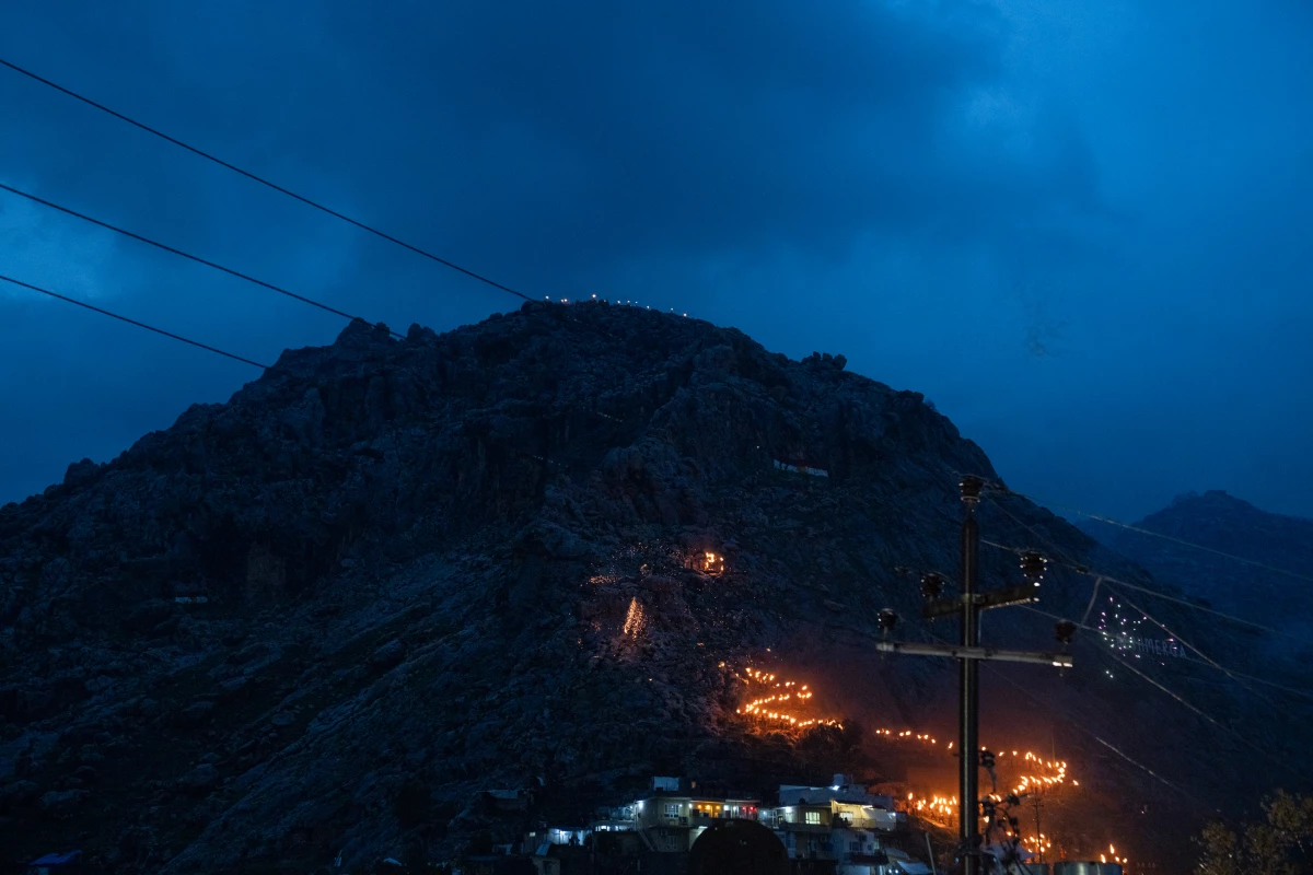 Traditionally, people in Akre carry flaming torches up the mountain to light a large fire on top. But this year's festivities were more subdued compared to past years because of the ongoing war in Iran and heavy rain.