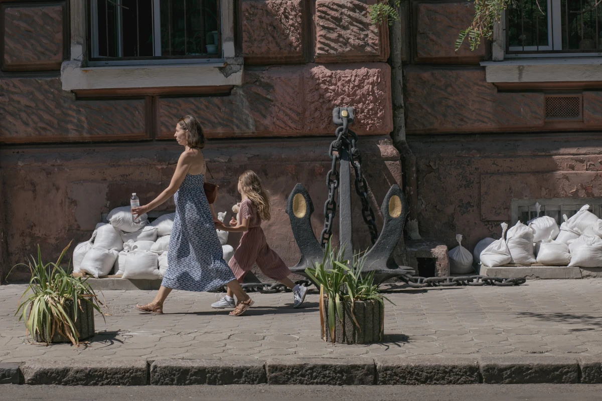 In a city that is full of life, signs of war are still visible. A mother and her daughter walk past sandbags, on Aug. 15, that are used to protect windows from the shelling.