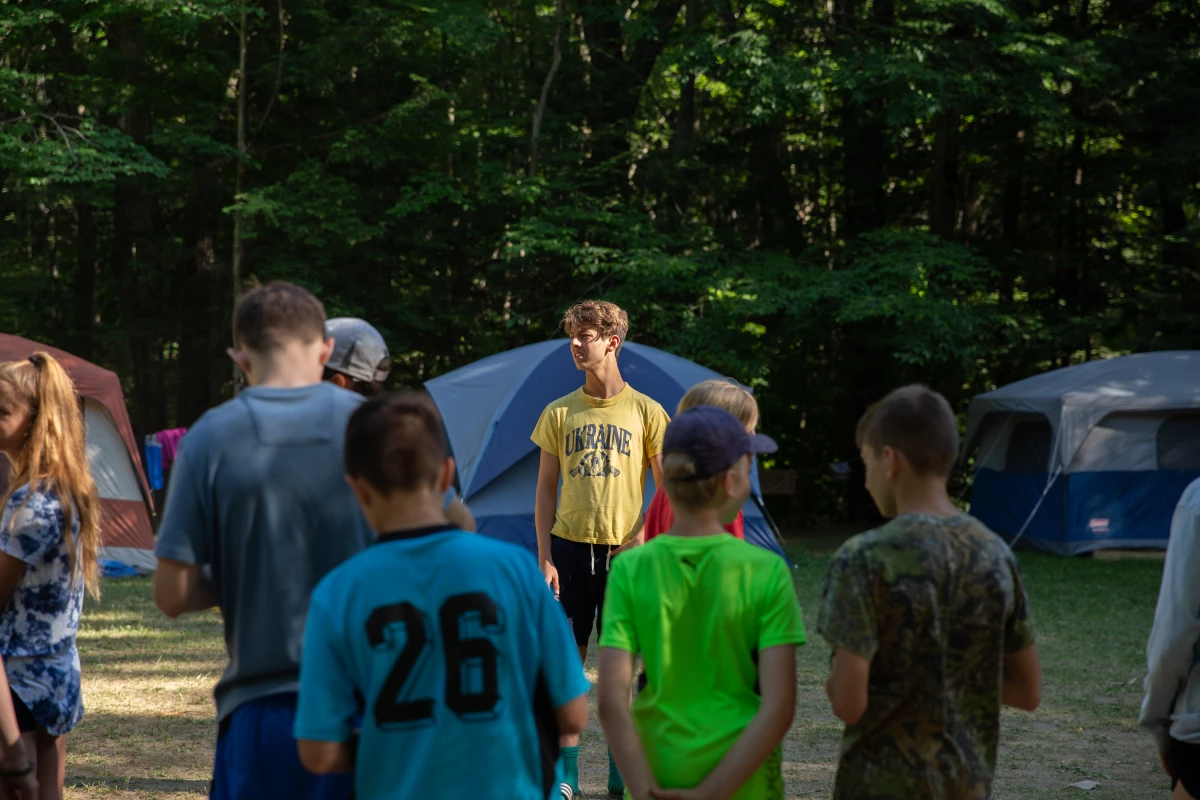 A druh, or male counselor to the older campers, calls his campers over to line up for the next activity.