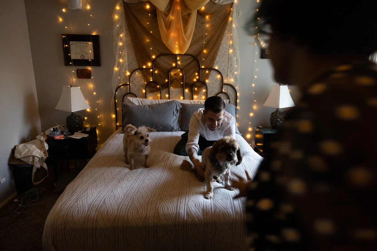 Thomas Guzowski greets his dogs, 13-year-old Mali and 15-year-old Yaretzi, as they climb onto the bed.