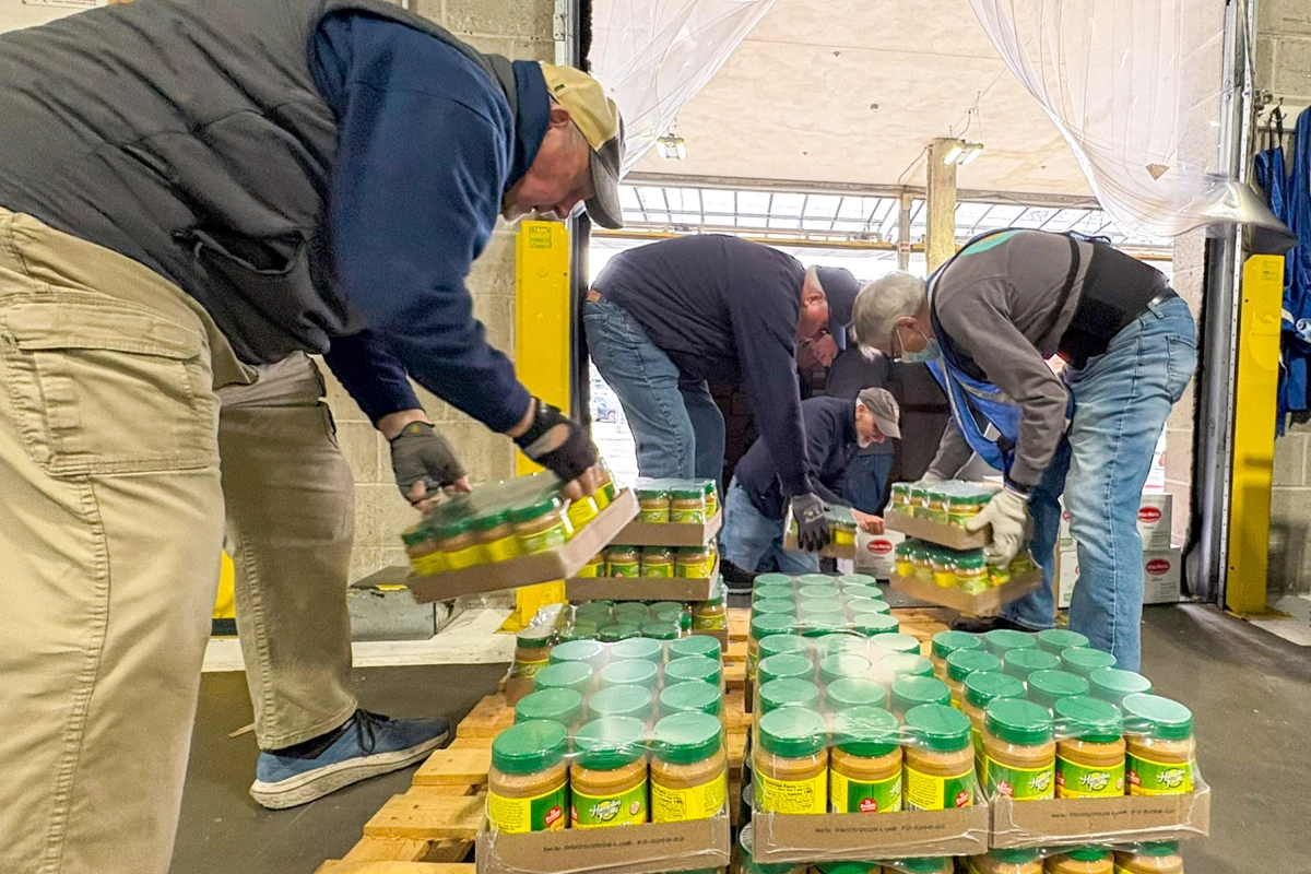 Richard Green (l) director of the Saint Matthew's Pantry in the Dorchester neighborhood of Boston, and fellow volunteers load peanut butter into their truck from the Greater Boston Food Bank.