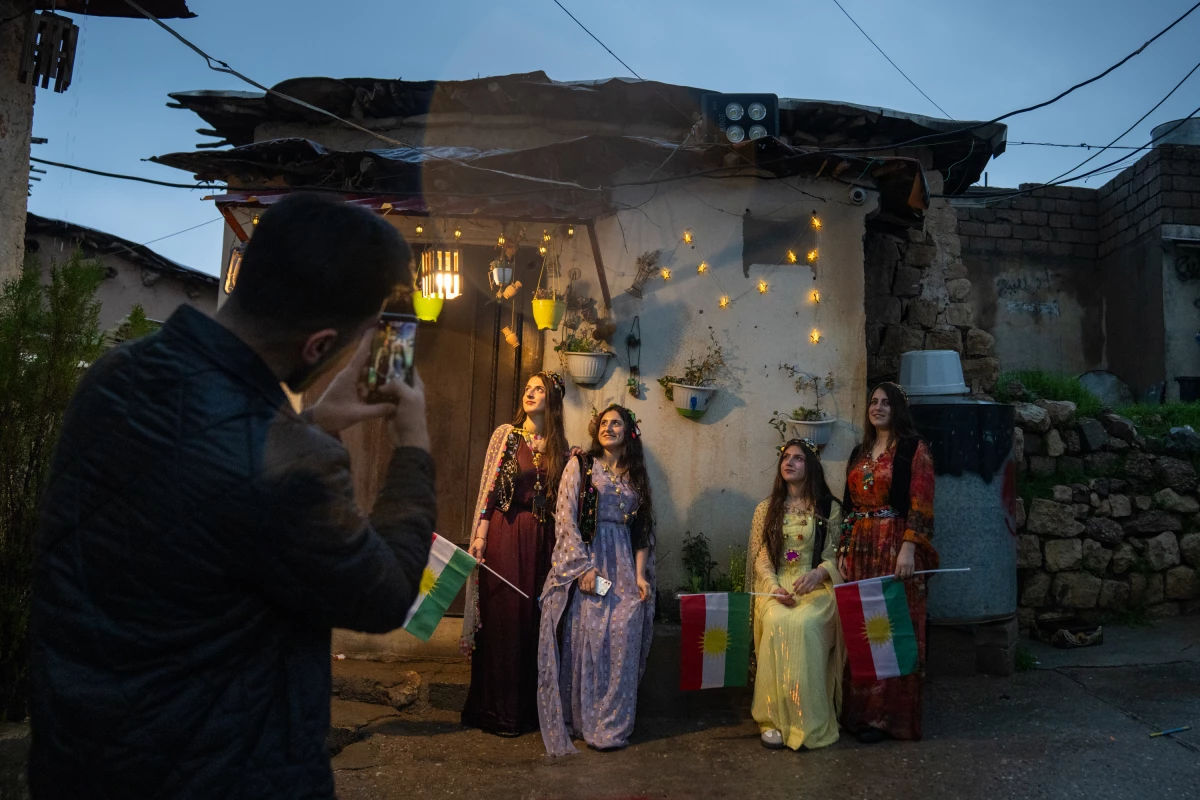 Women pose for photos dressed in traditional Kurdish clothing.