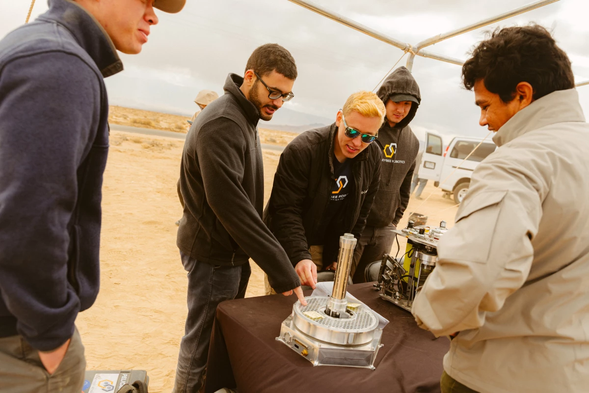 Representatives from Honeybee Robotics show off robot components.